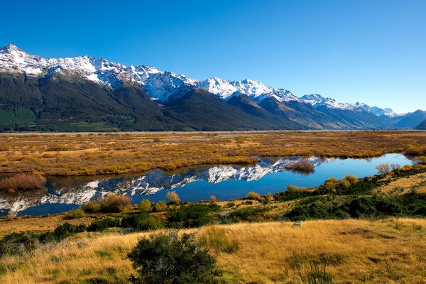 Il lago steppa e le montagne innevate si riflettono in esso