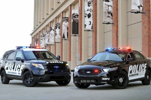 Два автомобиля ford police interceptor рядом со стадионом