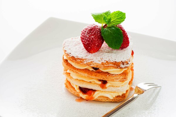 Nachspeise. Kuchen mit Sahne, Erdbeeren und Minze