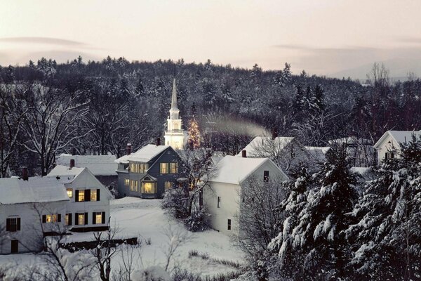 Winterliche Abendlandschaft mit Häusern und Kirche