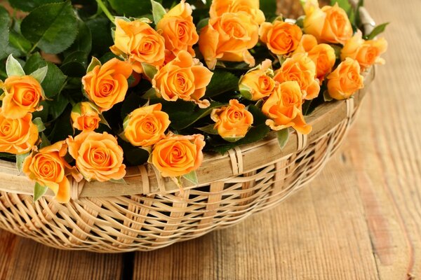 Bouquet de roses dans un panier sur une table en bois