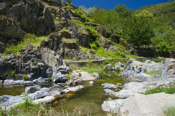 Ein ruhiger Fluss wäscht vergessene Felsen