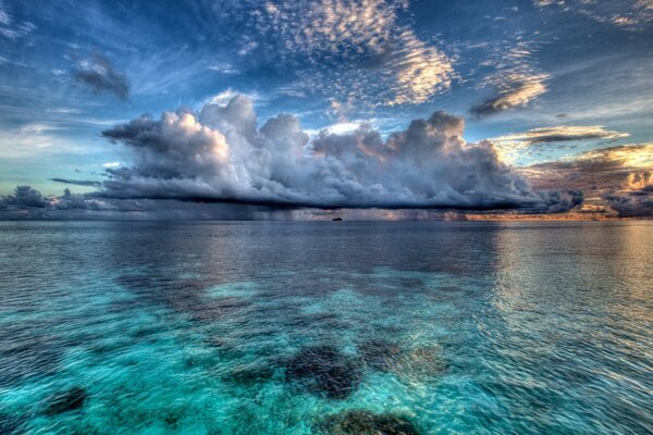 Klare Wolke auf blauem Wasser