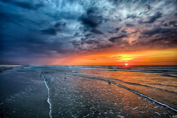 La puesta de sol ilumina el agua del mar agitado