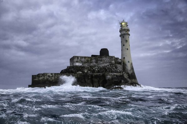 Lighthouse at the cliff in the middle of the Atlantic Ocean