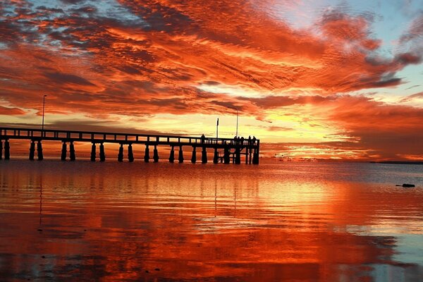 Dunkler Pier bei orangefarbenem Sonnenuntergang