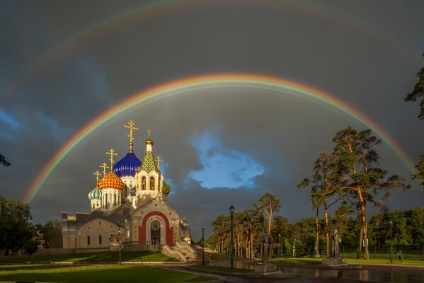 Double rainbow on the church among the trees