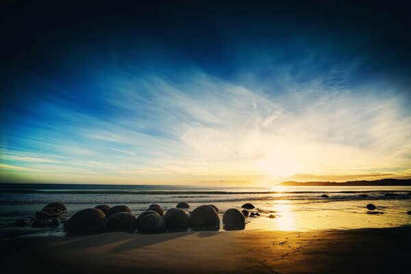 Die Steine liegen am Meer im Licht der untergehenden Sonne