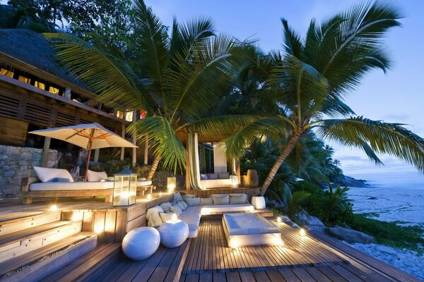 Villa by the sea with palm trees in the evening