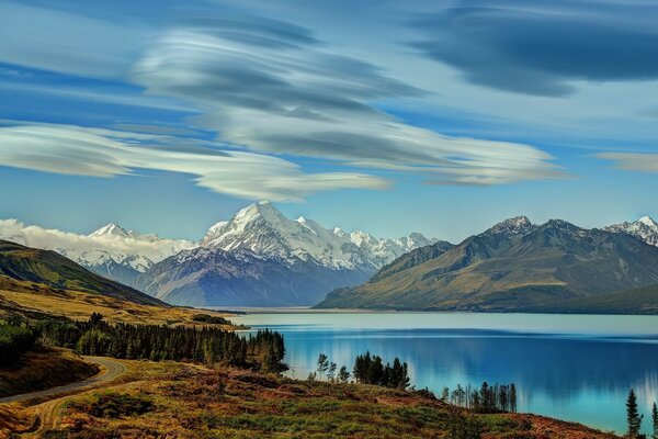 Picturesque nature of snowy mountains and lakes near the forest