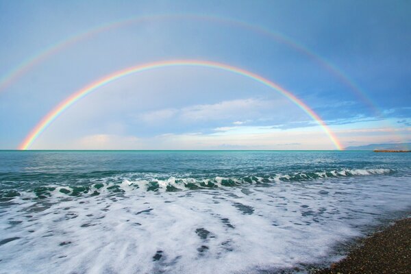 Two rainbows above the sea horizon