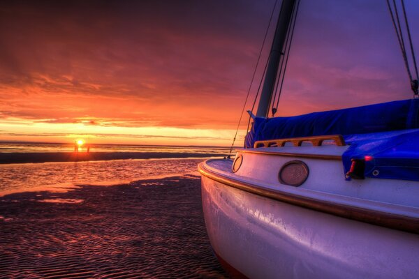 Yate cerca del mar en medio de la puesta de sol