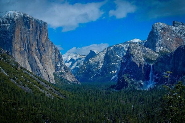 A waterfall can be seen against the background of powerful and high mountains