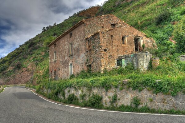 Edificio en ruinas en las montañas con una carretera