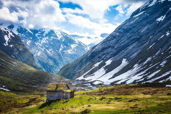 Paisaje Noruego con montañas cubiertas de nieve y rayos de sol a través de las nubes