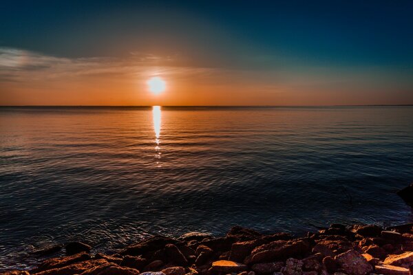 Straordinario paesaggio del sole del mattino in riva al mare