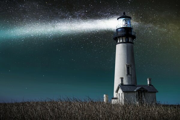The starry sky and the lighthouse in the field