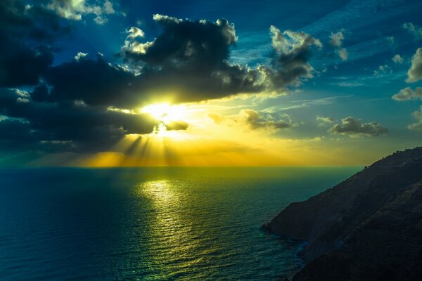 Puesta de sol en el mar entre montañas y acantilados