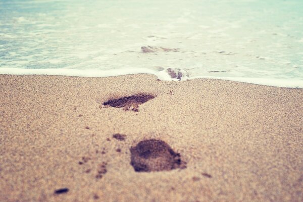 Das Wasser wird deine Spuren im Sand abwaschen