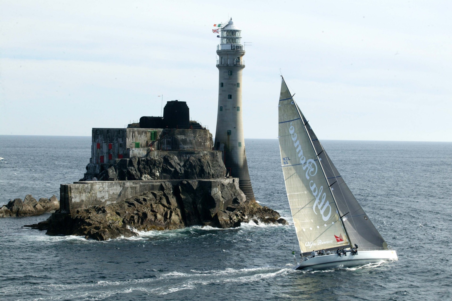 lighthouse tourists tour sea sailboats rock