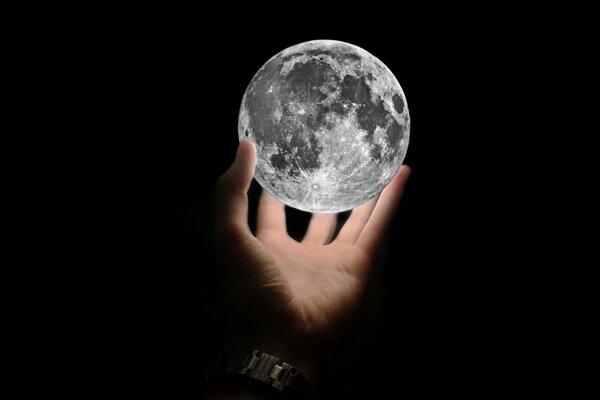 Hermosa Luna luminosa en la mano de un hombre