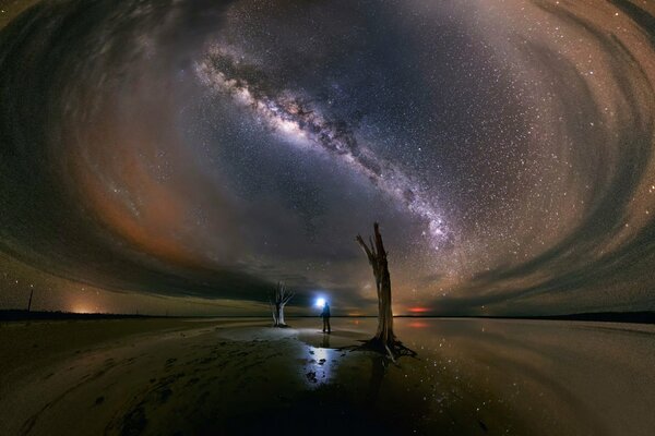 A man shines a lantern into the night and infinity