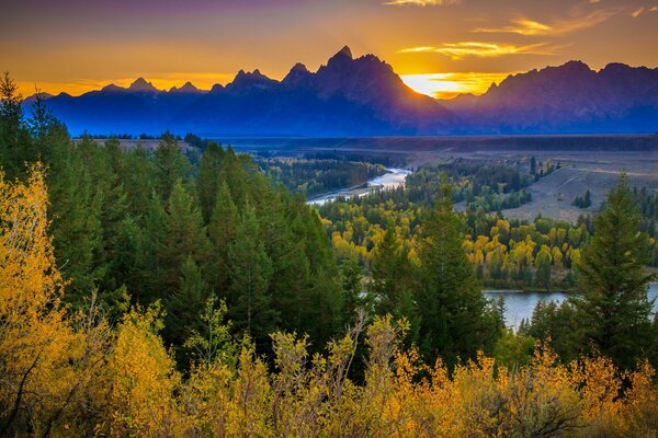 Autumn forest in the USA, sunset hides behind the mountains