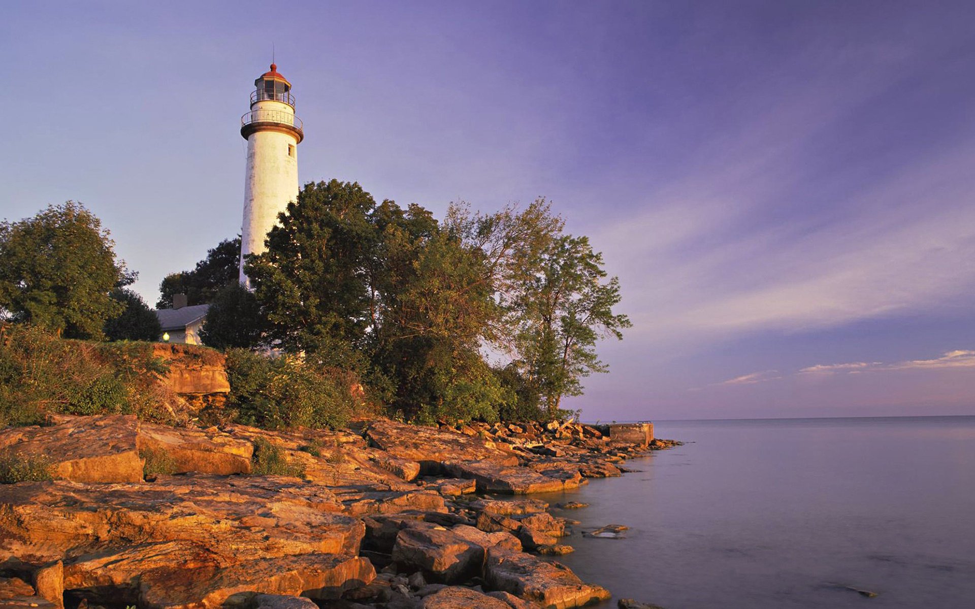 lighthouse lilac shore trees lake the sky stone