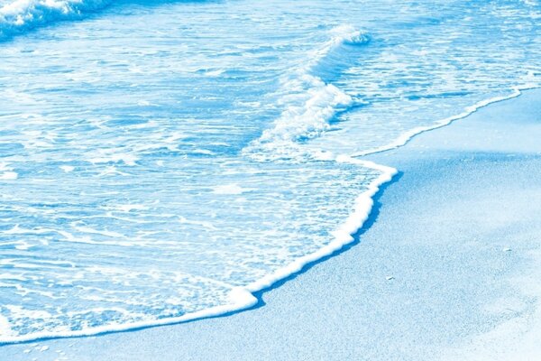 Лазурная пенистая волна на голубом песке