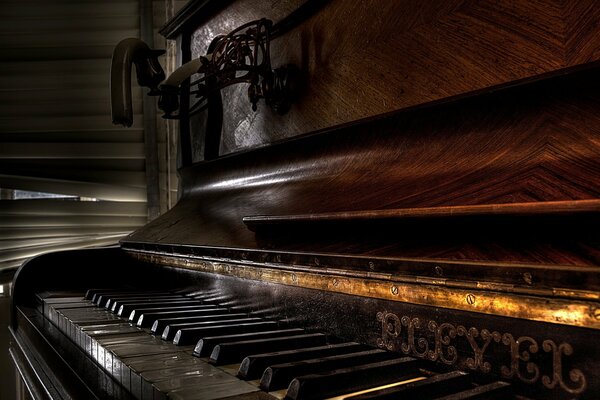 Zbliżenie starego drewnianego fortepianu w ciemnym pokoju