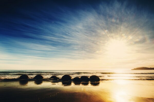 Sunrise on the ocean beach of New Zealand. Rocks in the waves