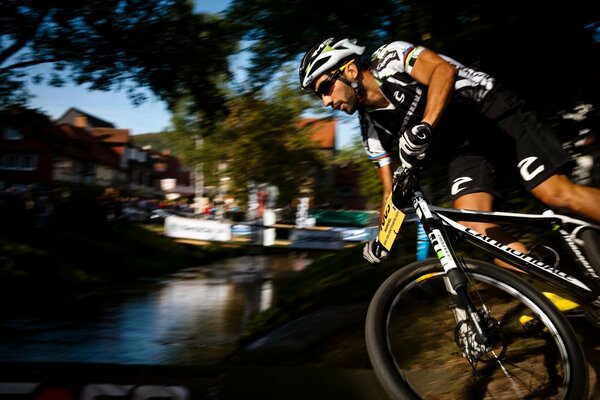 A cyclist crosses a river over a bridge