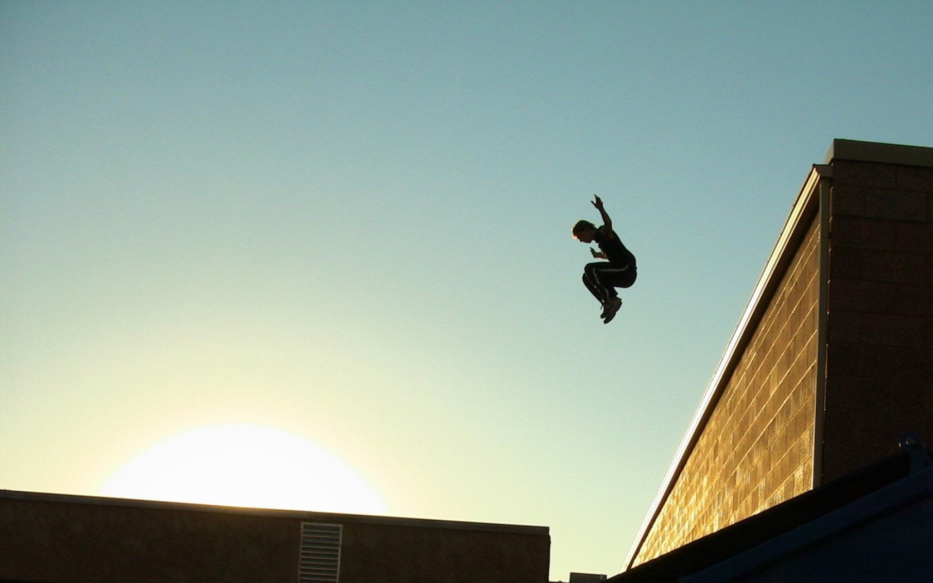 sport parkour ragazzo tetti città cielo sole