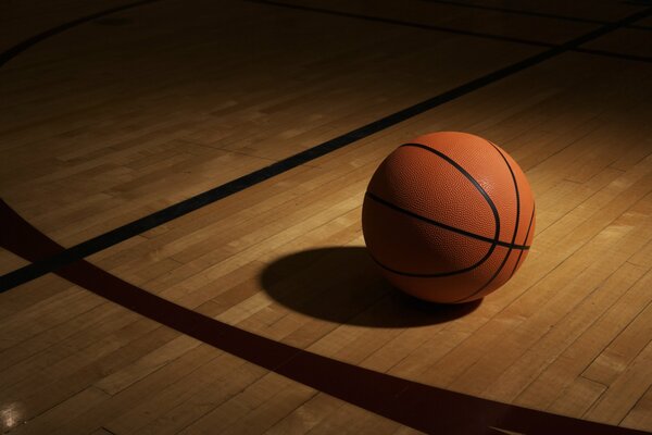 Basketball ball in the shade on the floor