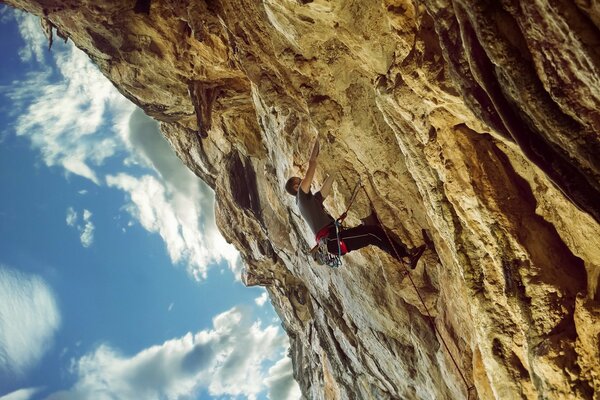 A young man climber climbs the mountain