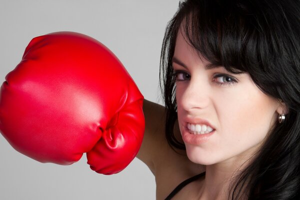 Chica agresiva en guantes de boxeo rojos