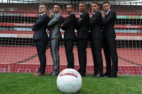 Football players pose against the background of the gate