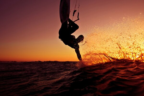 Surfer s jump on sunset background