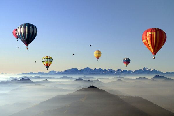 Hot air sports balloons in the sky above the clouds