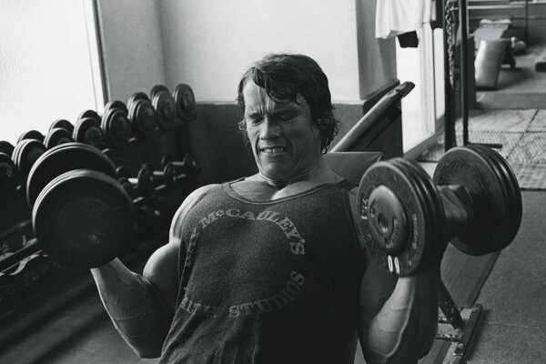 Arnold Schwarzenegger lifts dumbbells