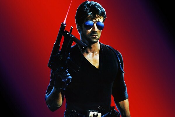 Sylvester Stallone in sunglasses with a gun