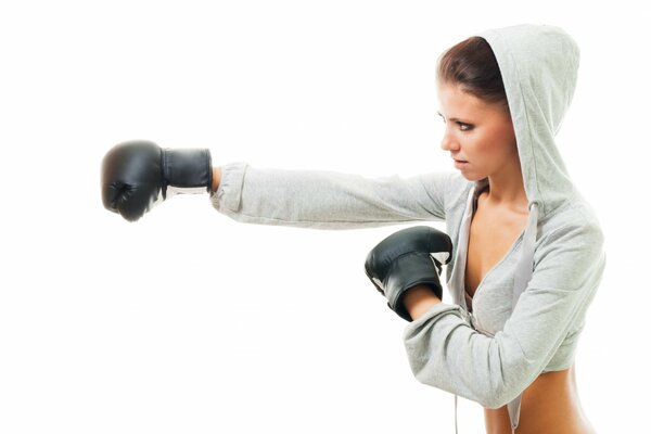 A girl in a hood is boxing on a white background