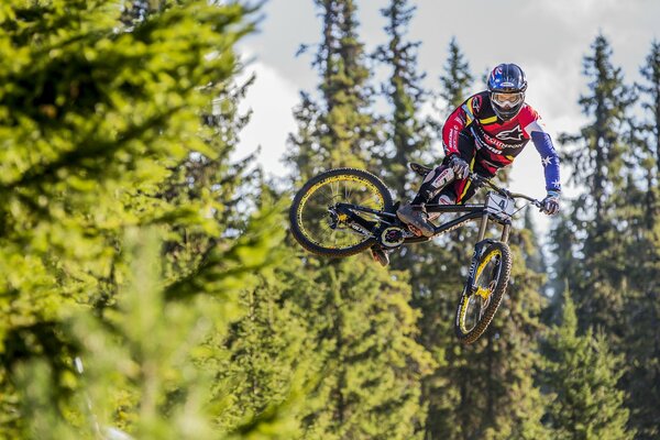 Un hombre en una bicicleta hace un truco en el aire