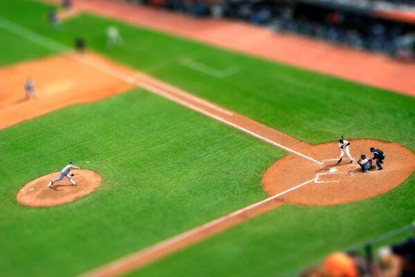 Sullo sfondo di un prato verde, un giocatore di baseball esegue un servizio