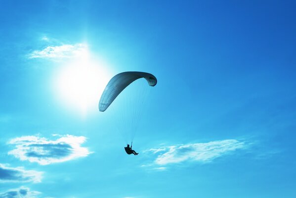 Fallschirmspringer fliegt in den blauen Himmel