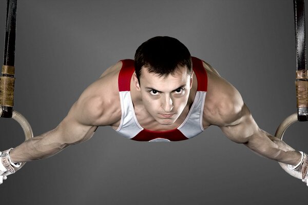 Athlete gymnast hanging on rings