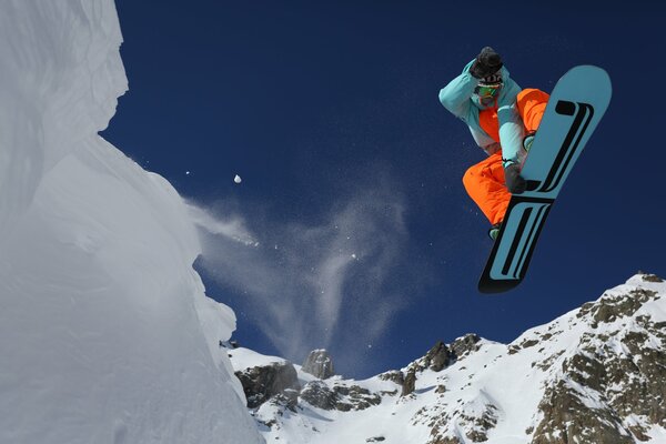 Snowboarder en sautant sur fond de montagnes