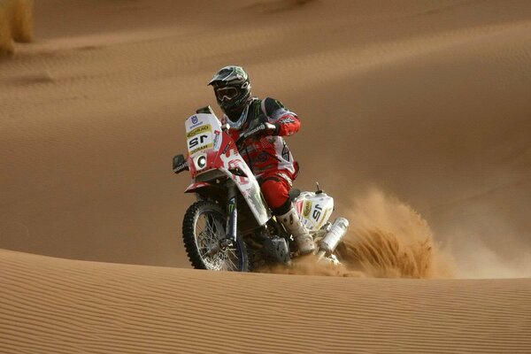 Motociclista sullo sfondo di dune di sabbia