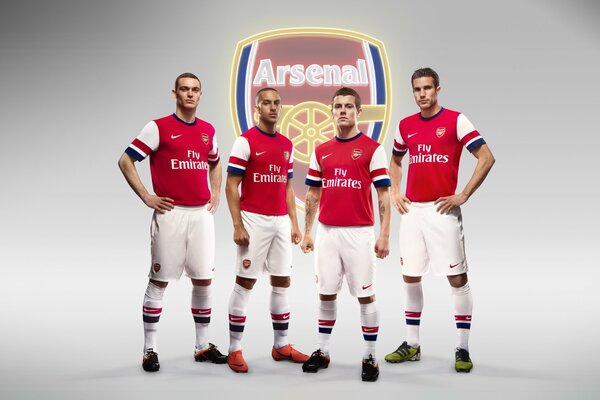 Arsenal football players on the background of the emblem.