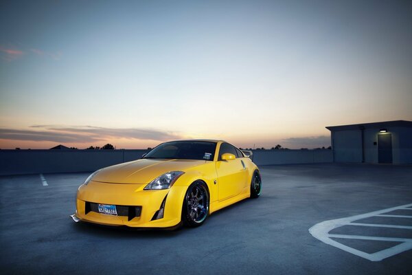 Nissan jaune tuning sur fond de ciel du soir